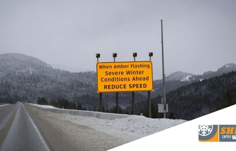 A road condition hazards sign on the side of a snowy road.
