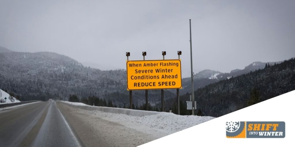 A road condition hazards sign on the side of a snowy road.