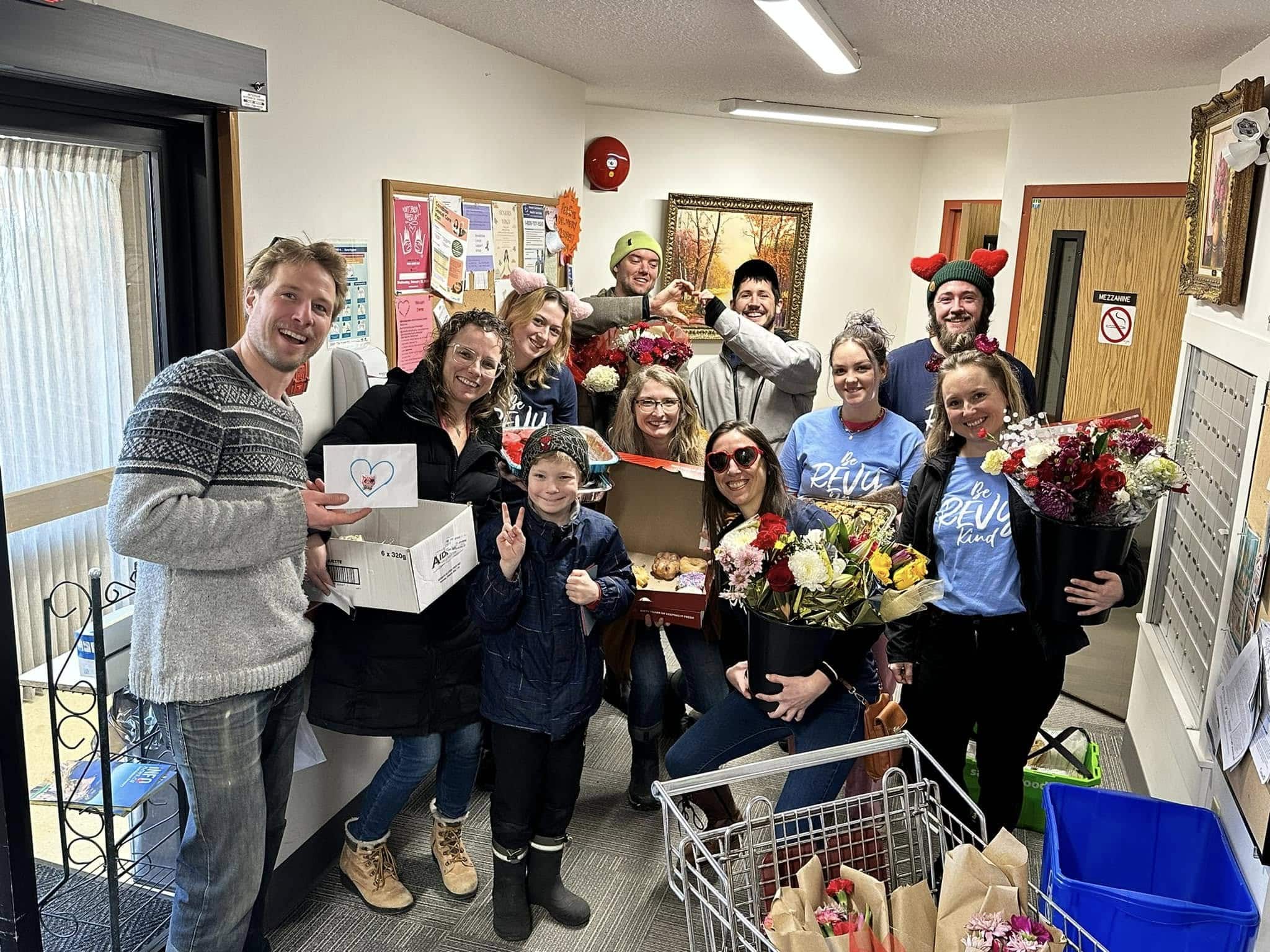 Revelstoke Unstuck volunteers and some residents of a local Senior's Assisted Living centre hold up the cards, flowers and baked goods made by the community.