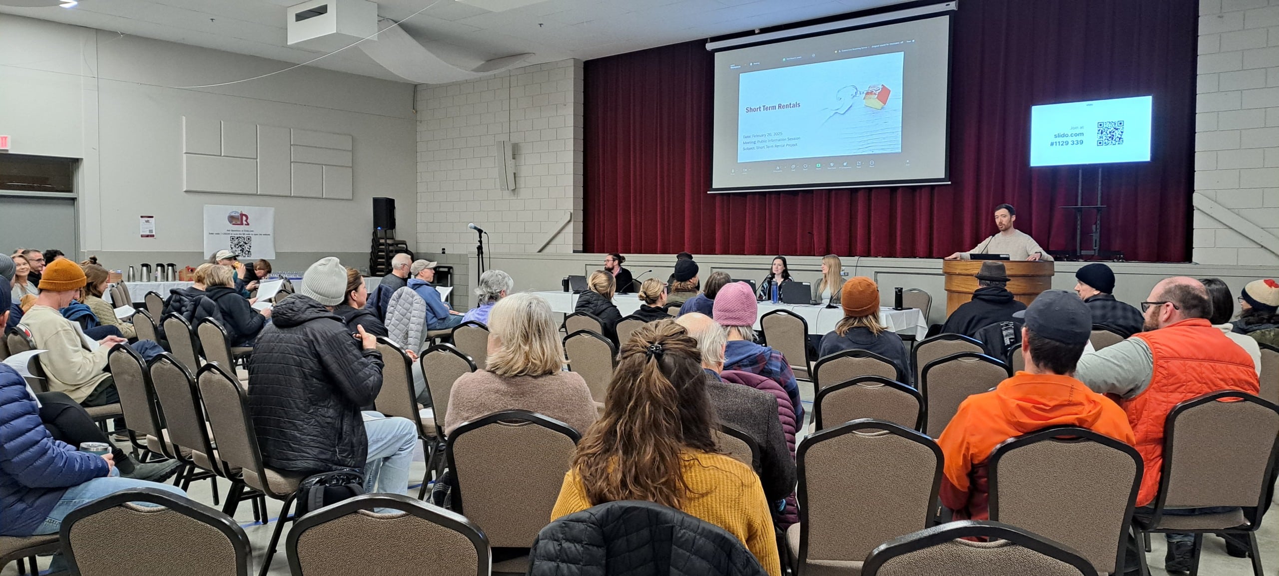 Residents sit in a gym for a Revelstoke STR information session