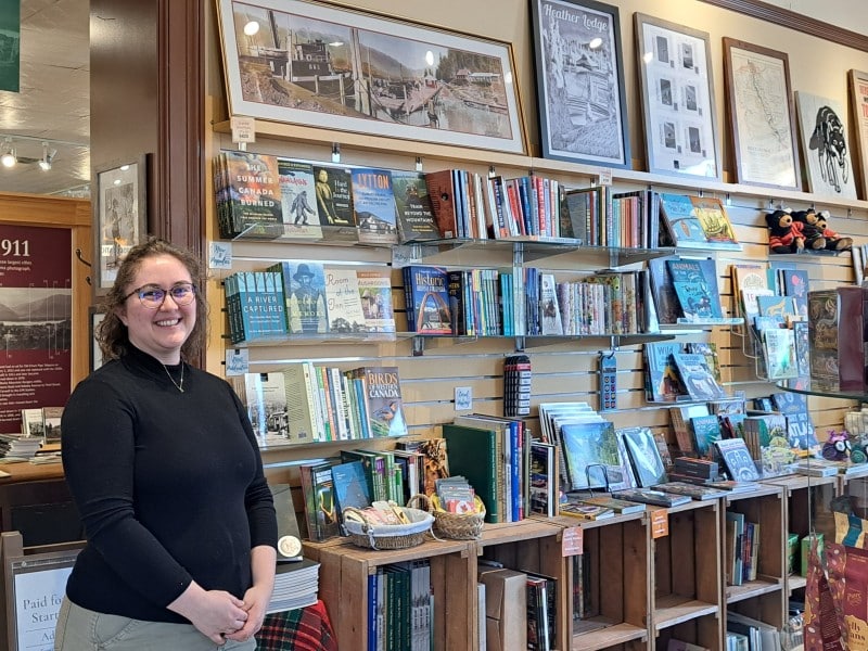 Laura Van Zant stands in front of a collection of books for sale at the Revelstoke Museum and Archives.
