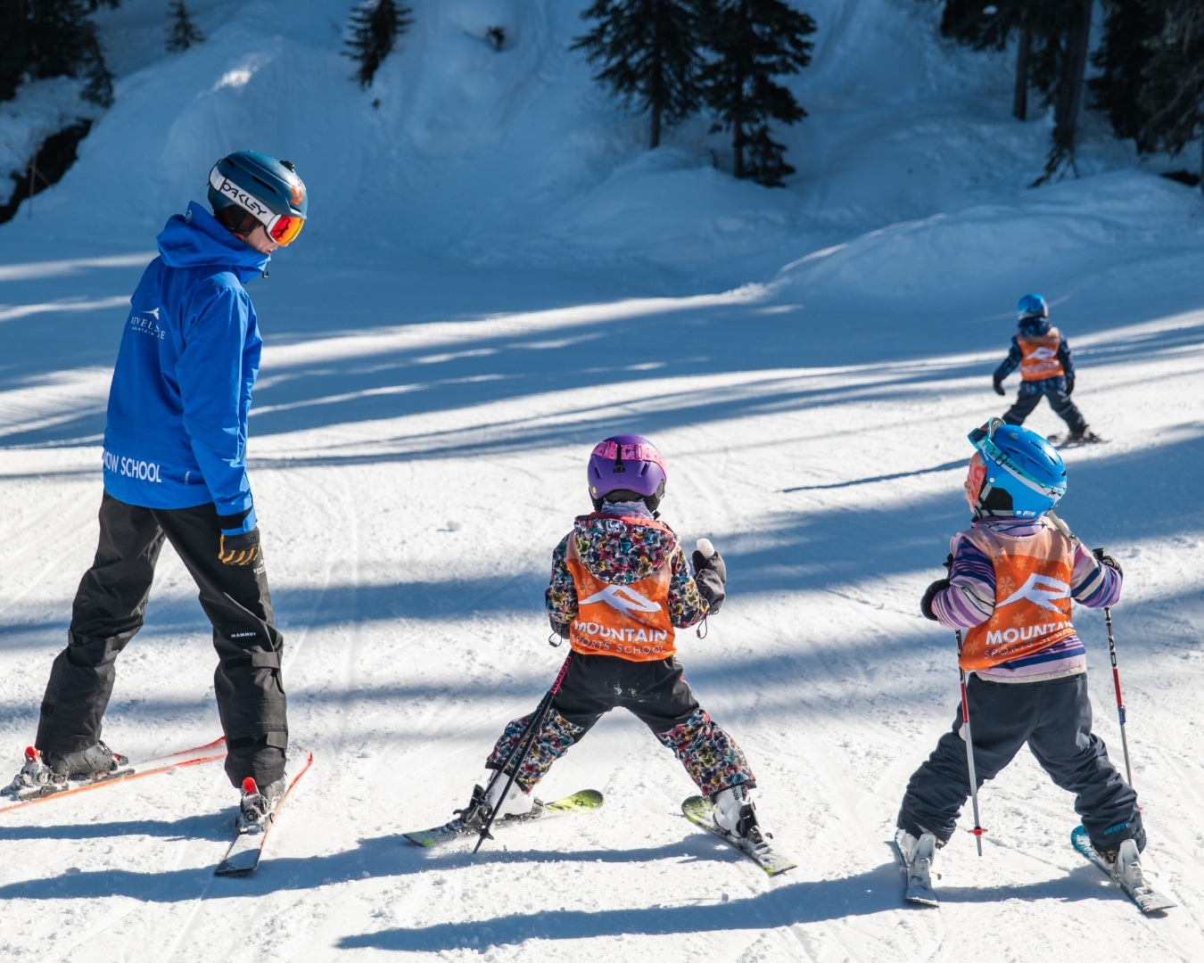 Two youth skiers and a coach head down a gently sloped hill during Revelstoke Mountain Resort 2024-2025 winter season lessons.