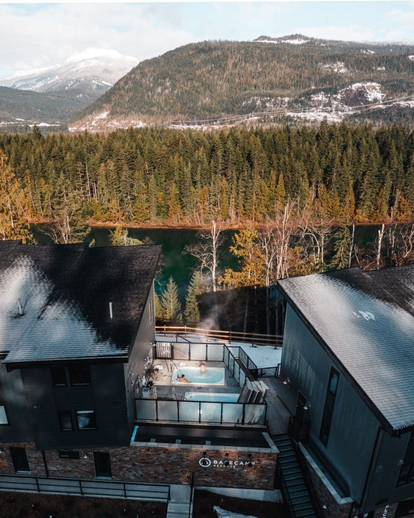 Ariel shot of the roofs of Revelstoke hotel Basecamp resort. The Columbia River spans in the background.