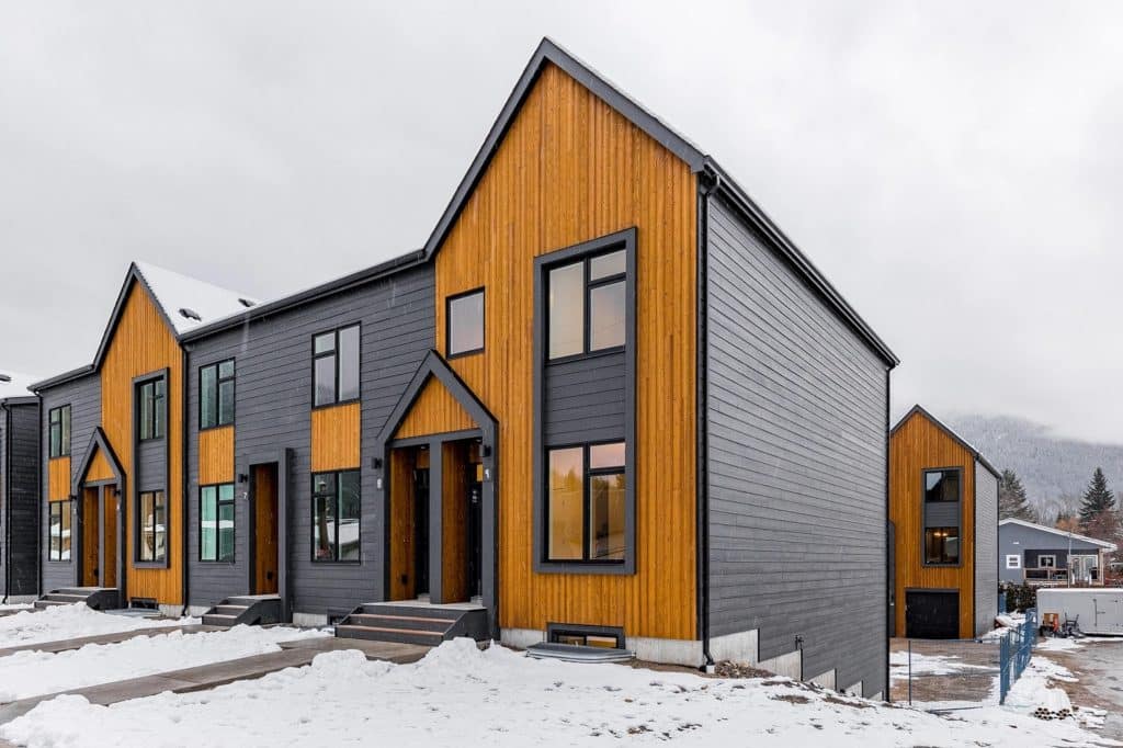 Boxfort Homes townhome, a row of two story side by side homes with wood accents and steel-grey metal siding.