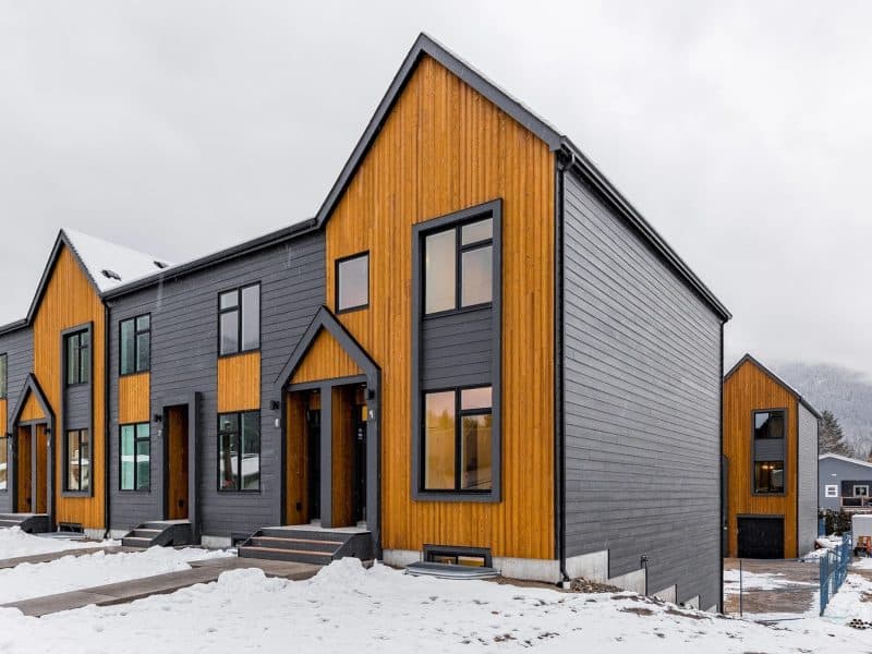 Boxfort Homes townhome, a row of two story side by side homes with wood accents and steel-grey metal siding.
