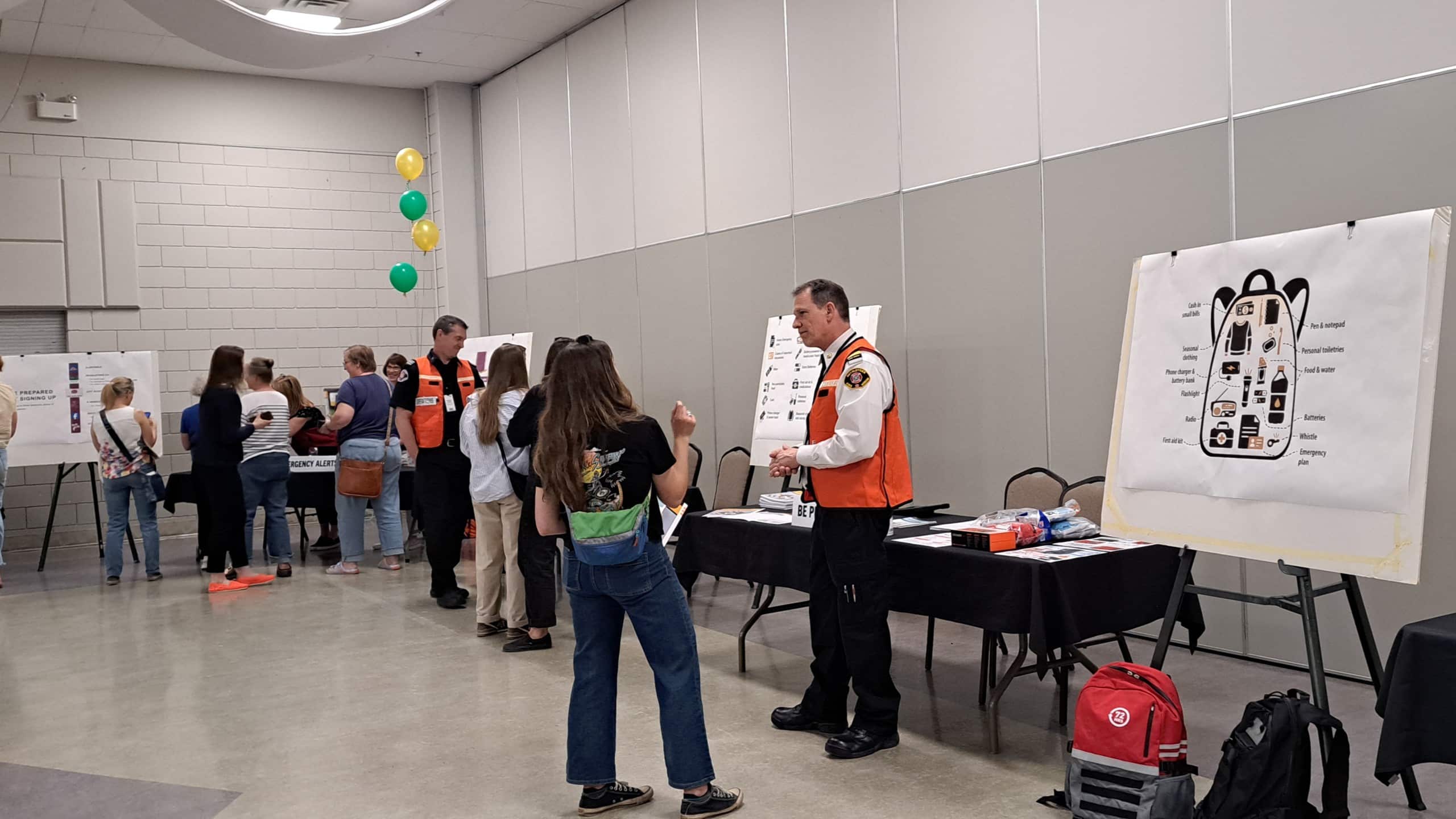 Revelstoke emergency preparedness town hall participants check out a poster showing what to put in a grab and go bag and also chat with the fire chief.