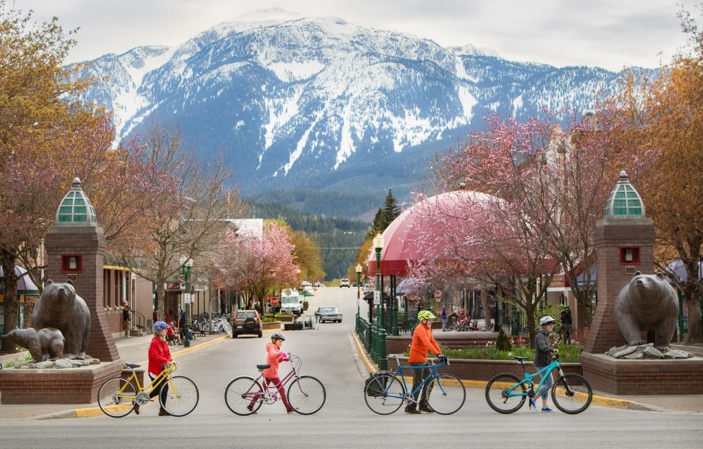 Go By Bike Week participants walk their bike across the street leading to Grizzly Plaza in Revelstoke