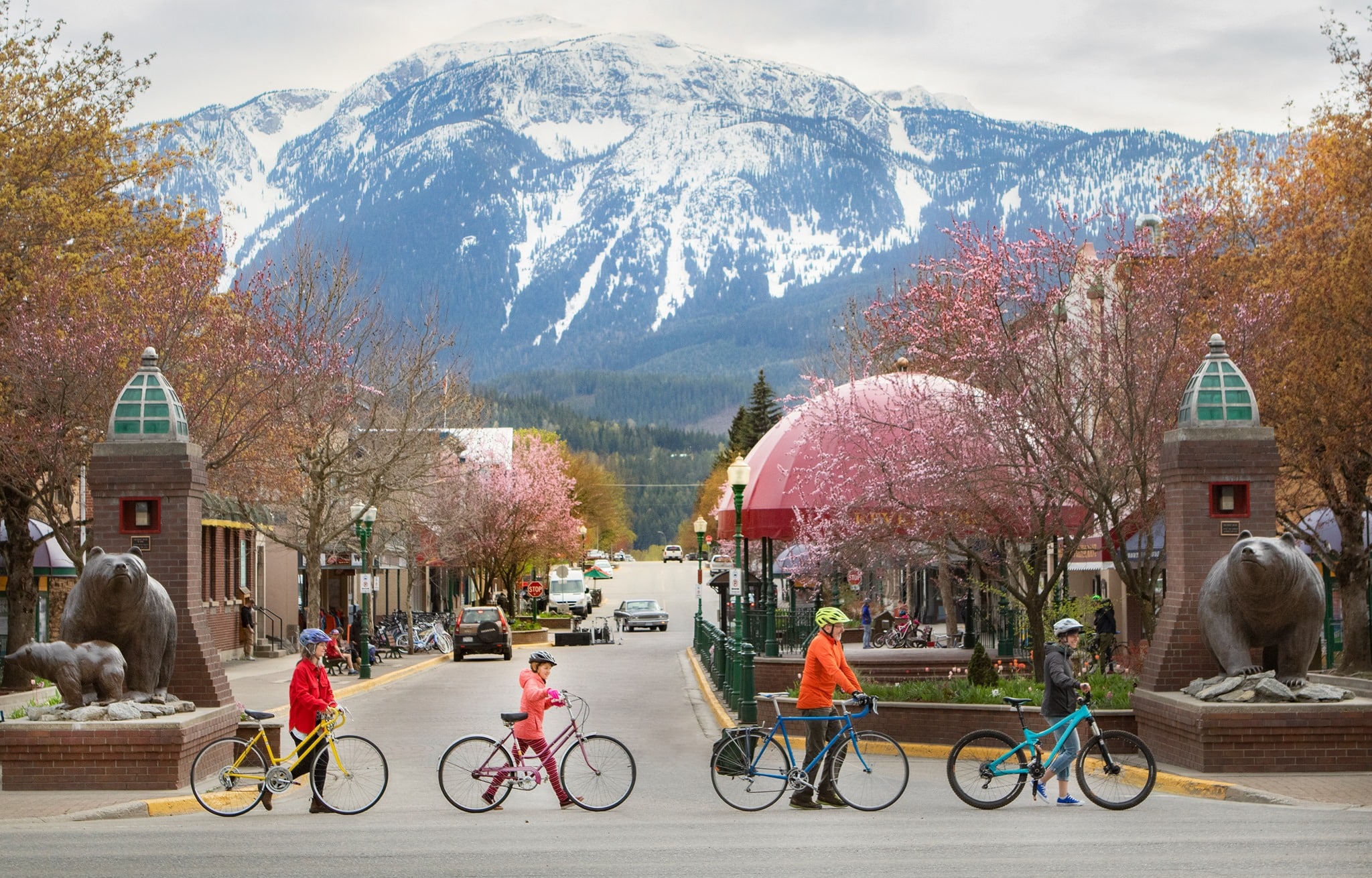 Go By Bike Week participants walk their bike across the street leading to Grizzly Plaza in Revelstoke