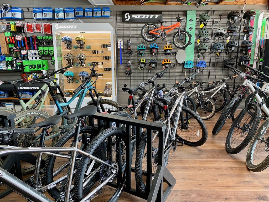 Interior of The Wax Bench, one of the bike shops in Revelstoke. Three racks of bikes can be seen and the wall is lined with gear.