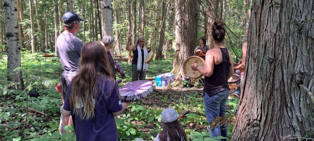 A group of people of various ages stand in a forest clearing, all holding different hand drums.

Part of Revelstoke's National Indigenous History Month celebrations.