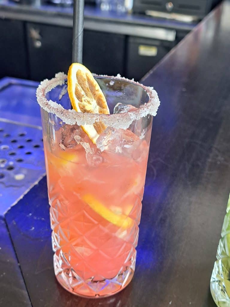 Old School Eatery Pink Panther mocktail, a pink drink in a tall glass with a sugar rim.