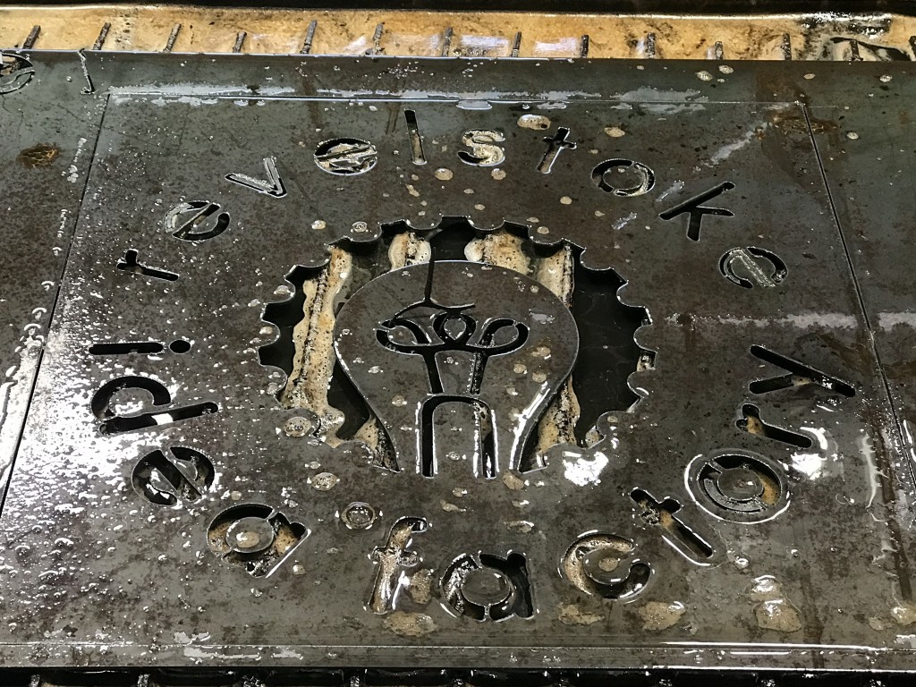Revelstoke Idea Factory logo cut into a sheet of metal