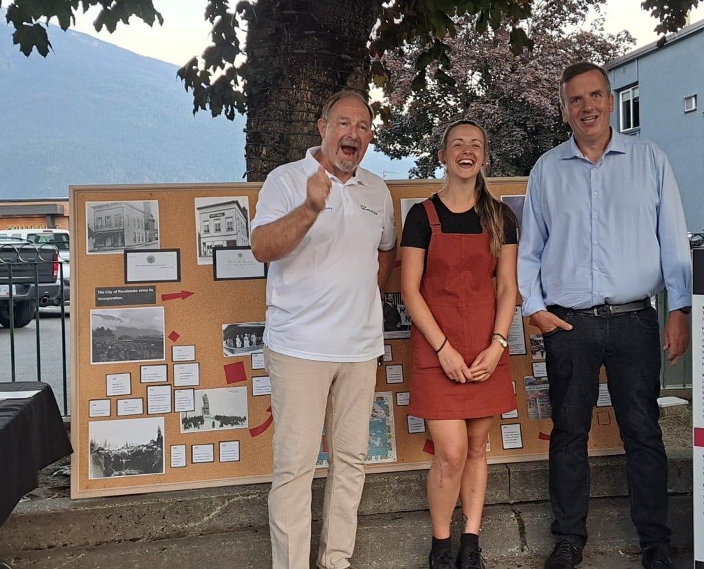 Gary Sulz, Francesca Williams and Tim Stapenhurst stnading in front of the corkboard Francesca used to plan the logo