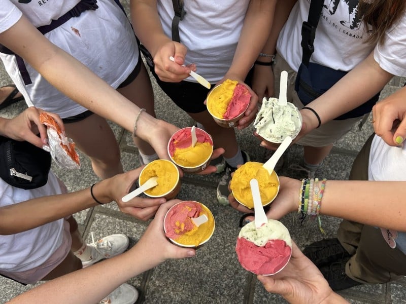Revelstoke Girl Guides standing in a circle all holding up a cup of gelato