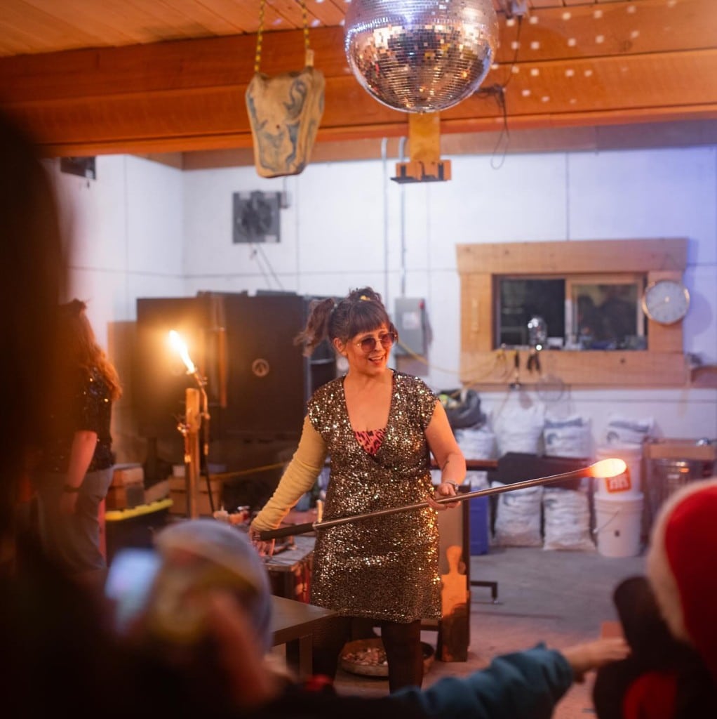 Big Eddy Glass Works Leah Allison spins a bulb of hot glass into shape in front of guests.