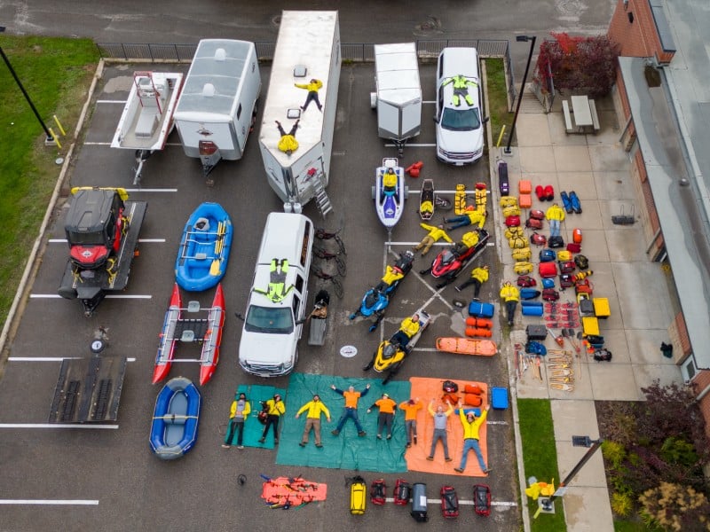Ariel gear shot of Revelstoke Search and Rescue with various vehicles, tarps, rescue gear and more lair out over an entire parking lot.