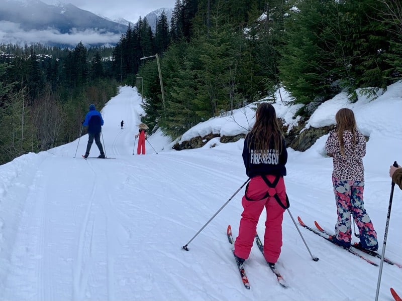 Stoke Youth Netowrk participants on Nordic skis heading down a long, snowy trail
