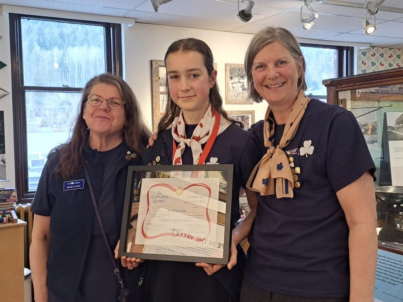 Avery Hornosty, Girl Guides Canada Cord recipient in the middle, with Michelle Cole and Sue Nielsen on either side. All are smiling at the camera