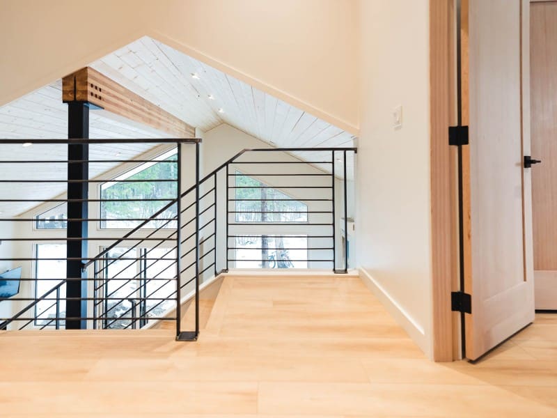 Monashees Drafting and Design interior shot of a large upper floor landing with wood floors, wood walls and wood ceiling. Windows are bringing in a lot of light from different angles