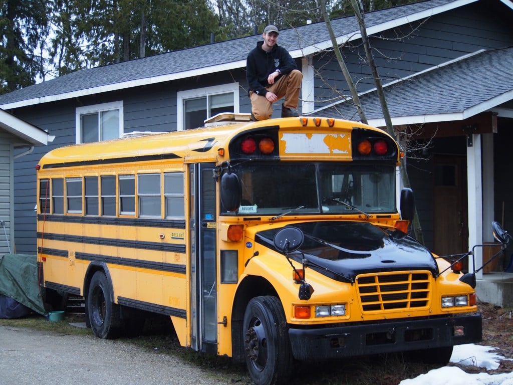 Turi Duhamel standing on the roof of a yellow school bus
