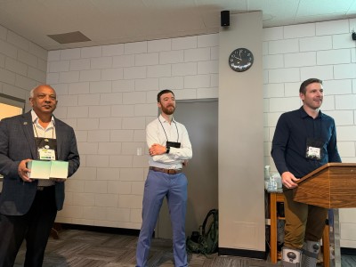 Three men standing at a podium presenting at SILGA 2026