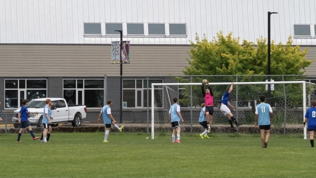 A collection of soccer players from the Revelstoke Drop-In Soccer Co-Ed Clash soccer tournament. all playing a game on the field.