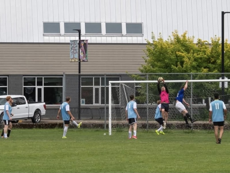 A collection of soccer players from the Revelstoke Drop-In Soccer Co-Ed Clash soccer tournament. all playing a game on the field.