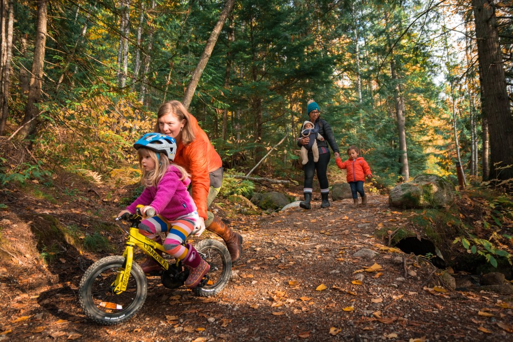 Family walking and biking on a Mount Revelstoke National Park path during the fall. Photo part of the Canada Strong Pass story.