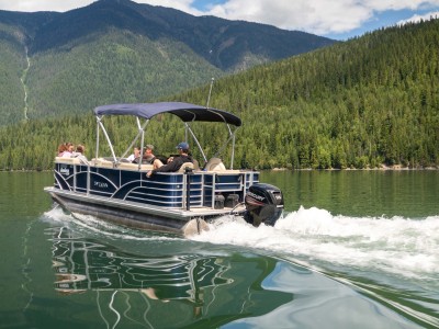 Pontoon boat on a lake with a small wake behind it