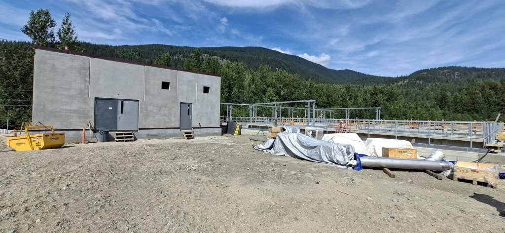 A wide shot of the Revelstoke wastewater treatment plant upgrades focusing on the new treatment building and one of the new holding tanks